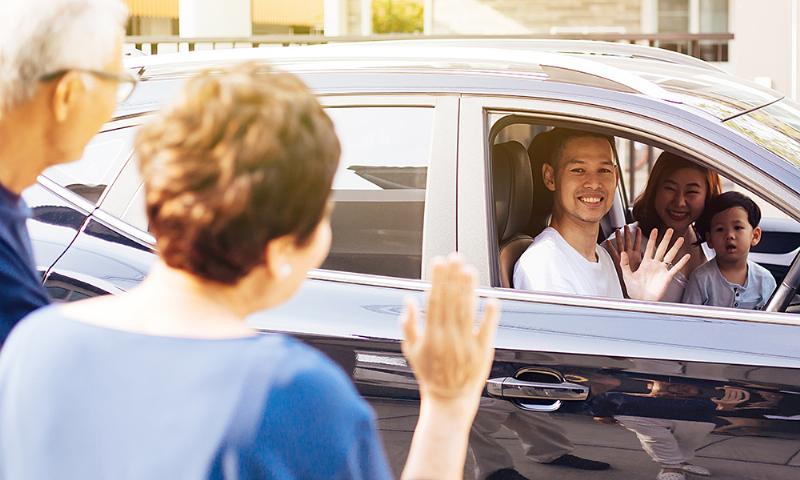 Một nhóm bạn trẻ đang ôm tạm biệt hoặc vẫy tay một cách vui vẻ, thể hiện các cách nói tạm biệt tiếng Anh thân mật và đời thường.
